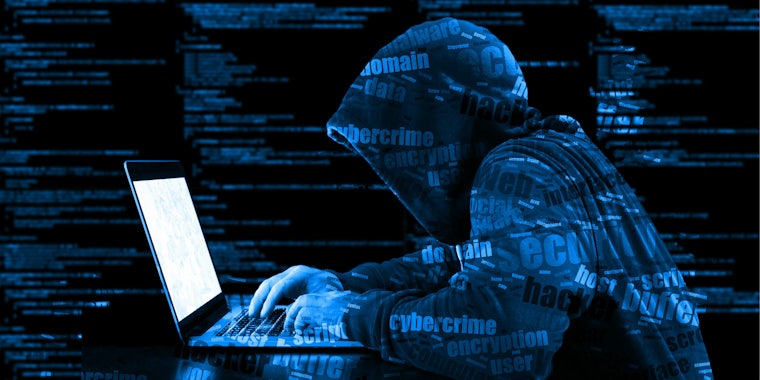 hacker on computer sitting at desk malware virus