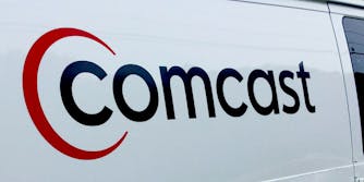 The Comcast logo on the side of a white van.