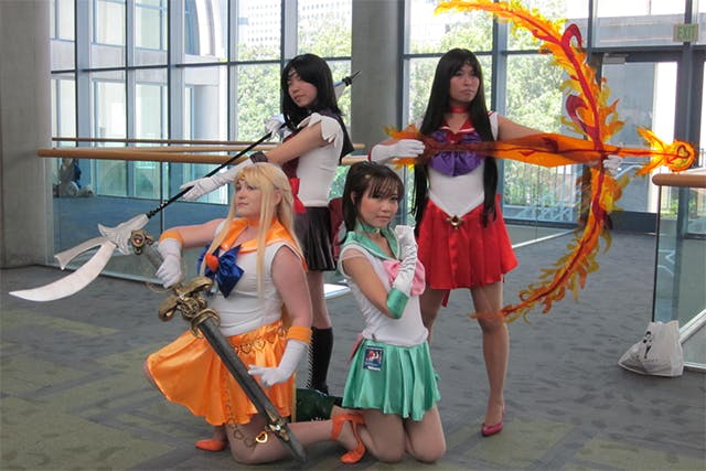 photo of sailor moon cosplayers at Fanime, arranged back to back facing outward, with weapons drawn.