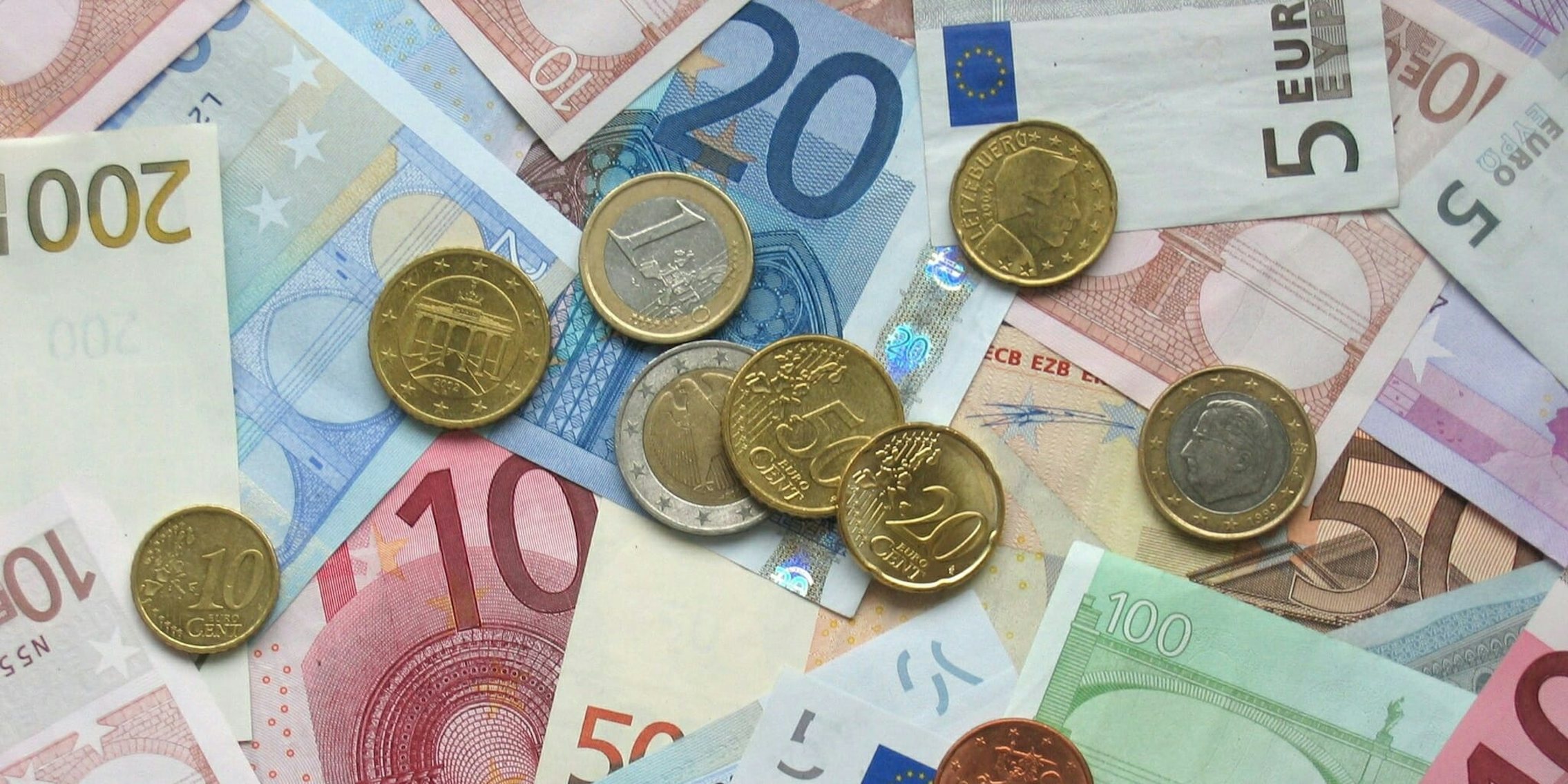 Euro coins and banknotes in a pile.