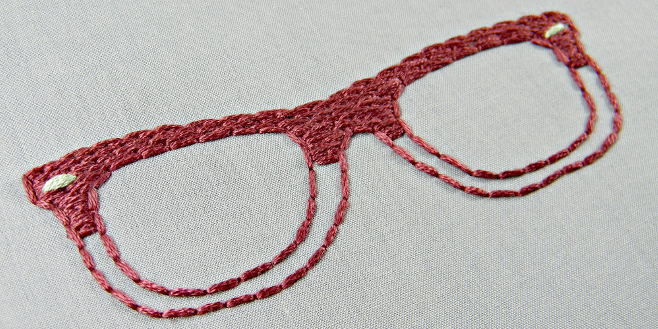 Red embroidered glasses on gray fabric