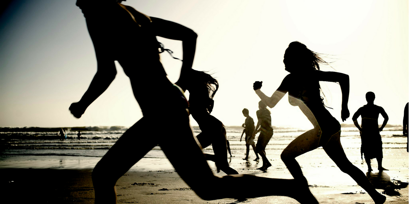 Silhouettes of girls running on a beach