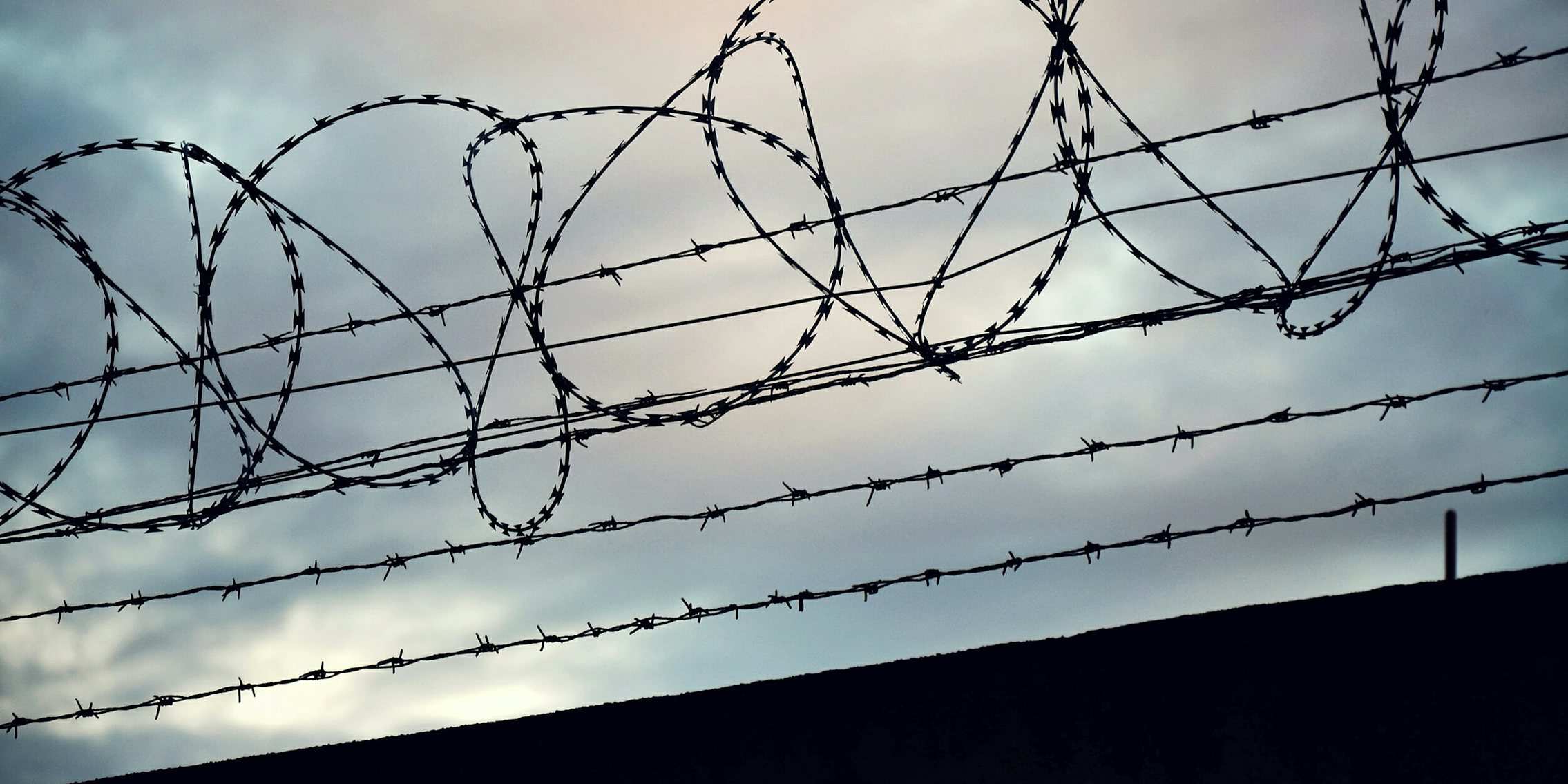 Barbed wire fence around prison wall