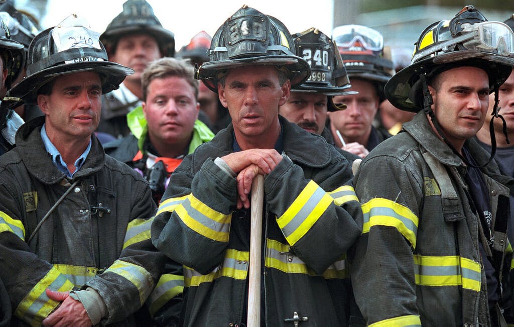 Firefighters look on Friday, Sept. 14, 2001, as President George W. Bush surveys the destruction left by terrorist attacks on New York City. Photo by Paul Morse, Courtesy of the George W. Bush Presidential Library
