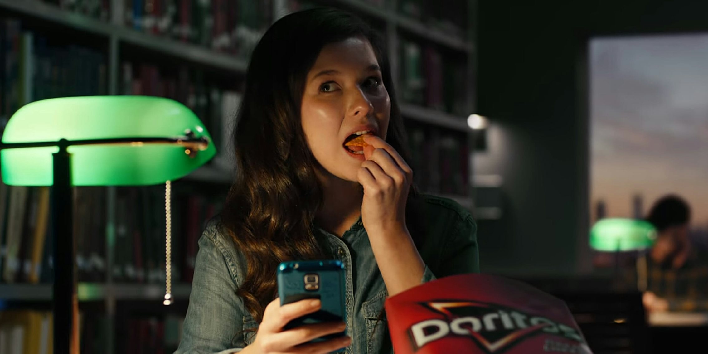 Woman eating Doritos in a library