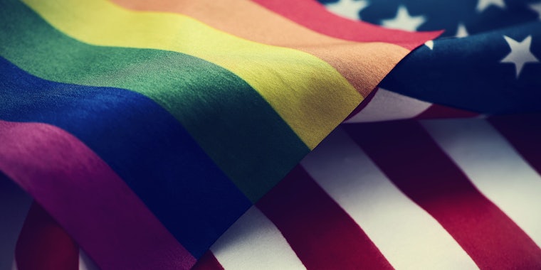 closeup of a gay pride flag and a flag of the United States of America