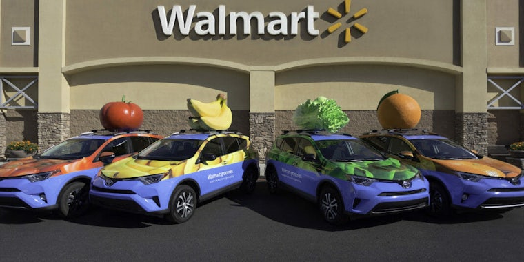 Walmart grocery deliveries vehicles, which are purple with fruit atop their roofs