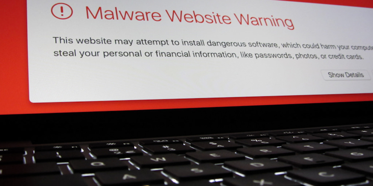 Image of malware website warning above a keyboard