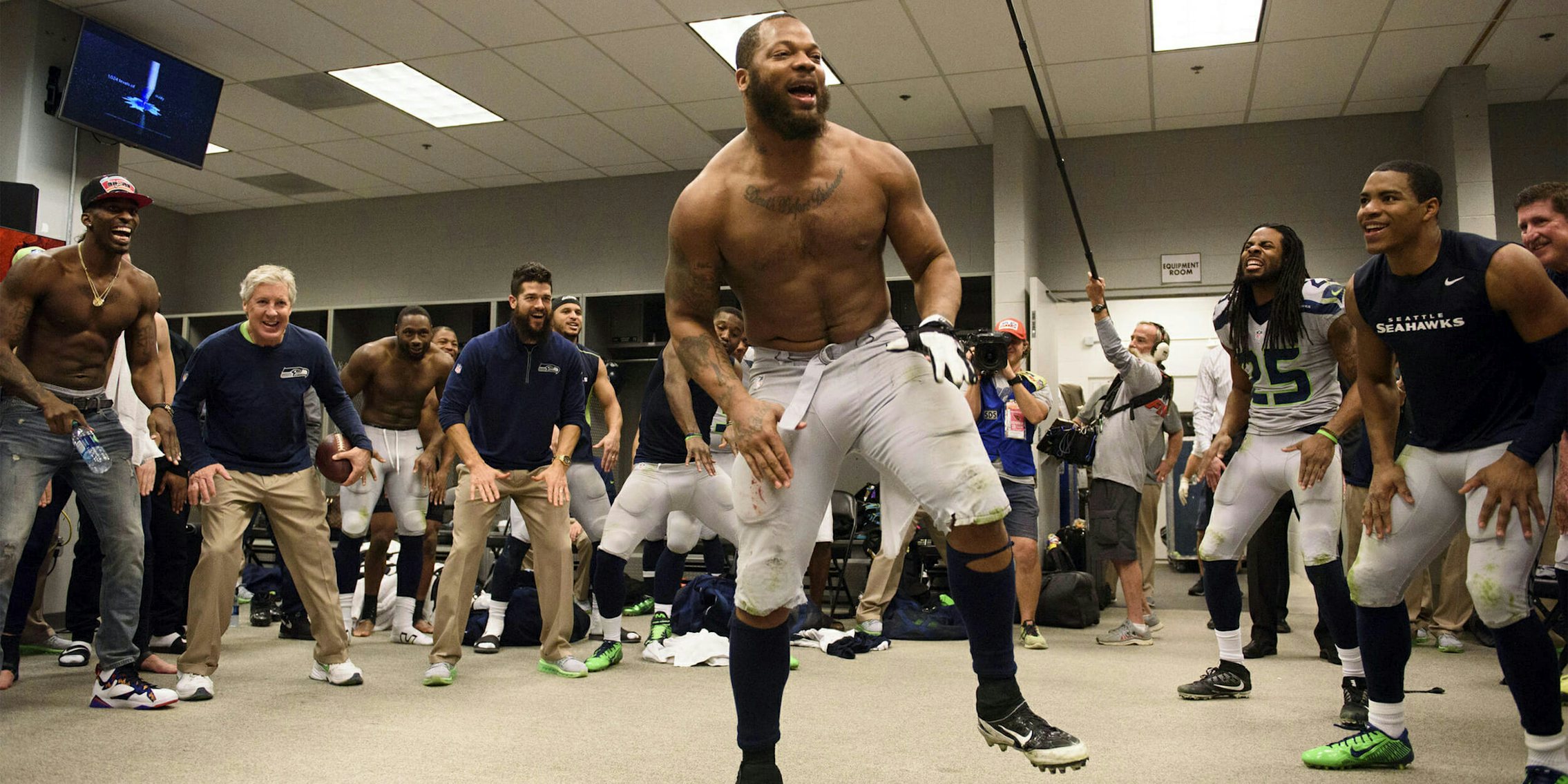 Defensive end Michael Bennett leads the team in the now-traditional post-victory dance in the locker room.