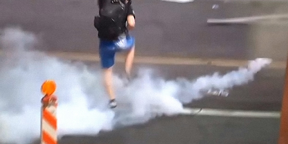 Protestor kicks smoke grenade back toward police
