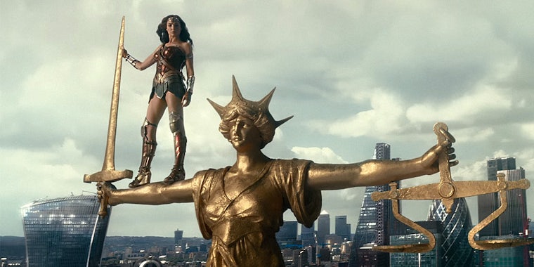 Wonder Woman standing on gold statue