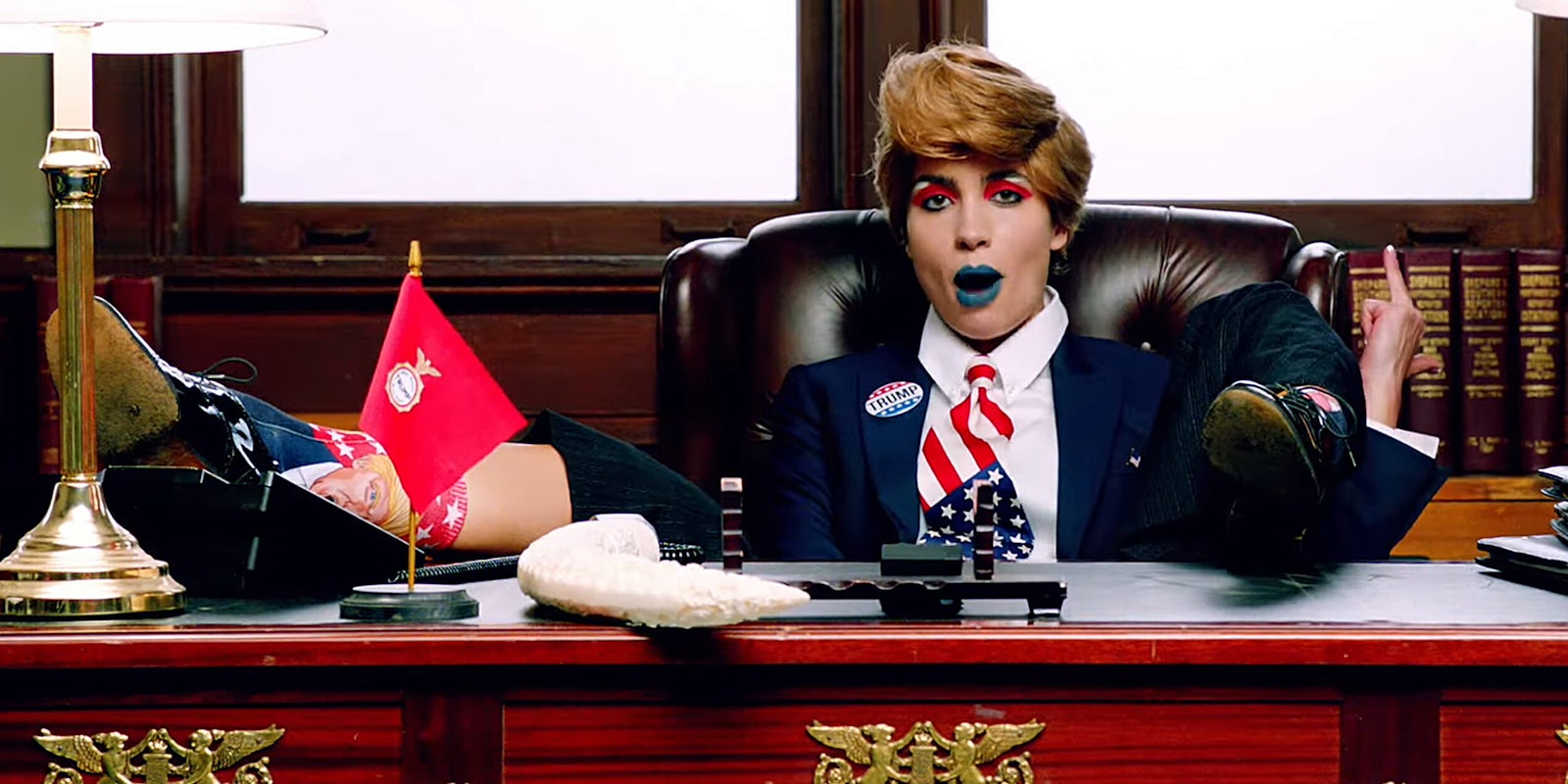 Singer from Pussy Riot sitting at desk dressed as Trump