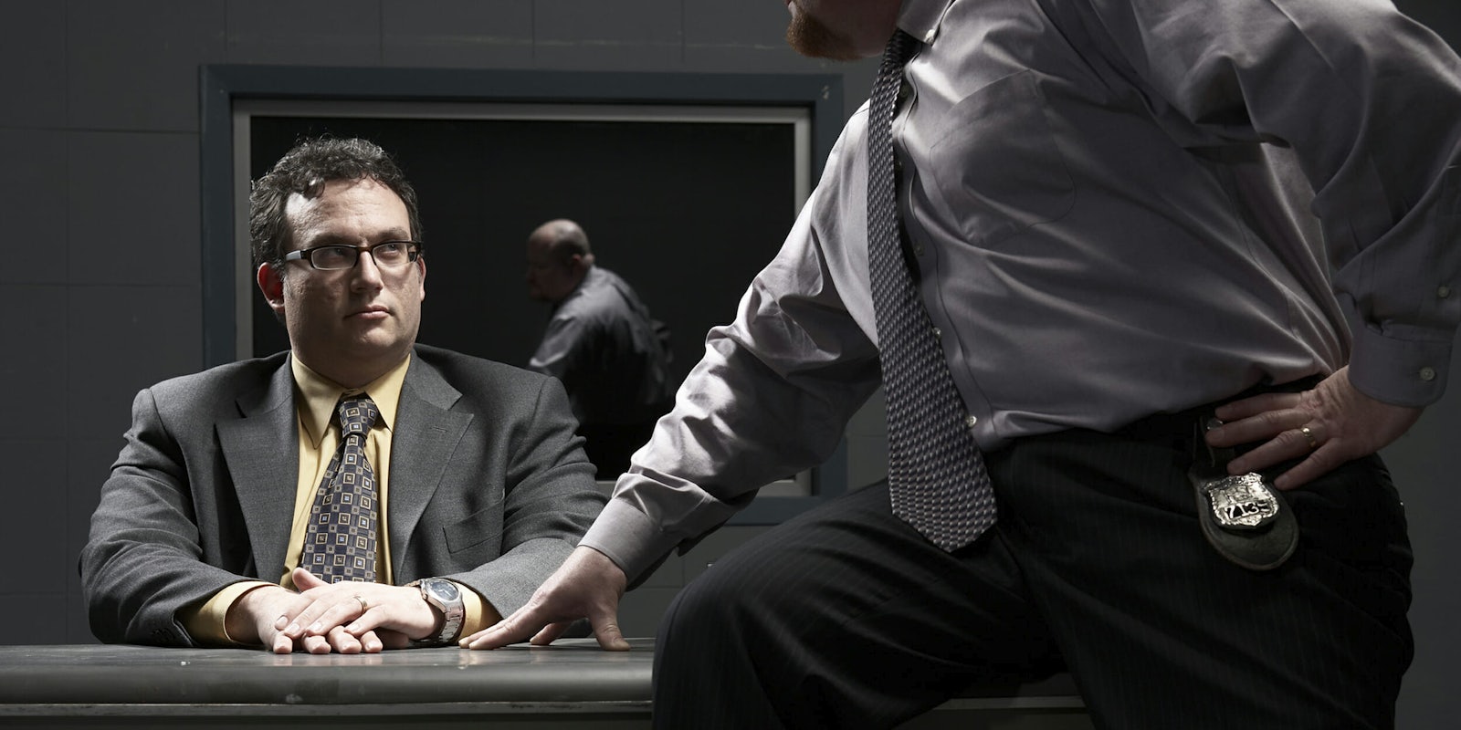 Man sitting at desk in interrogation room