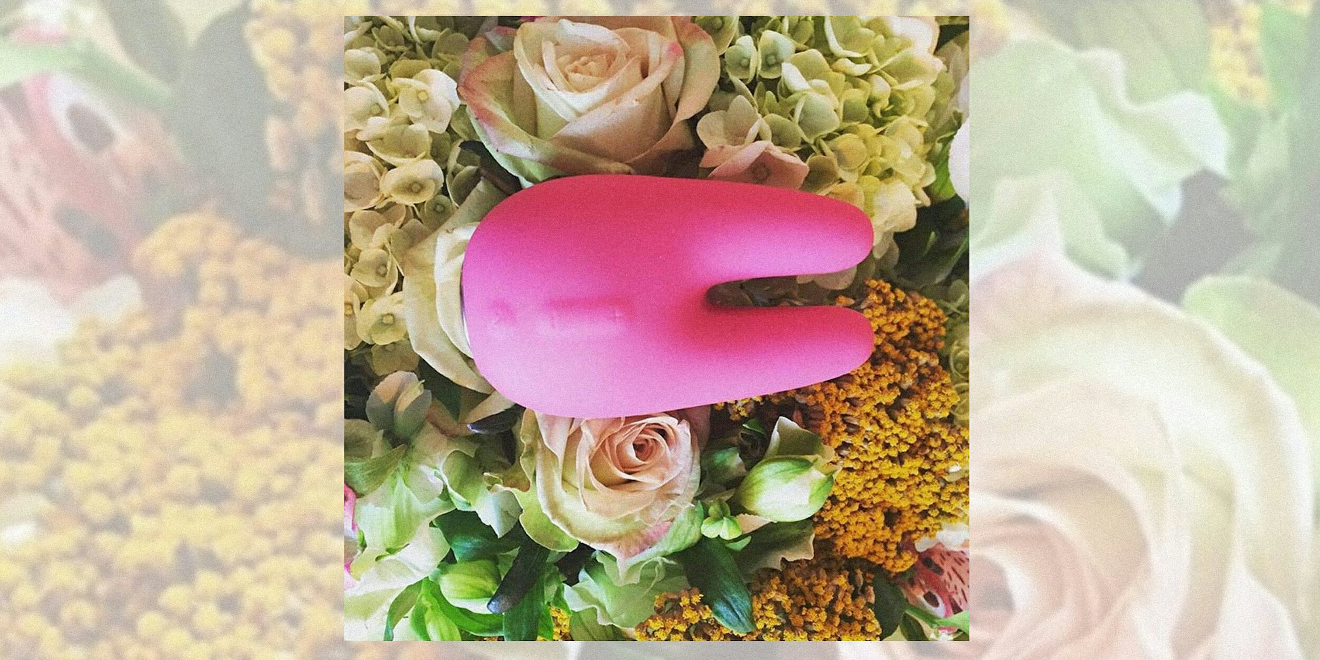 sex toys for women : Pink two-pronged vibrator on flowers