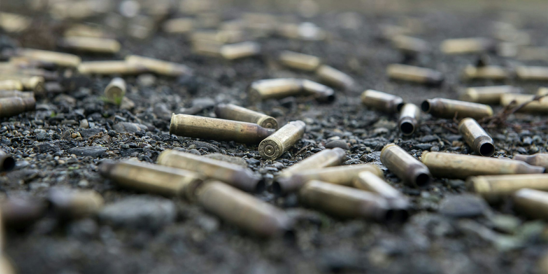 Spent 5.56 mm ammunition casings litter the ground