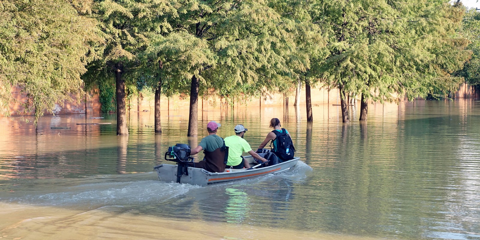 Three people in a boat during Hurricane Harvey.