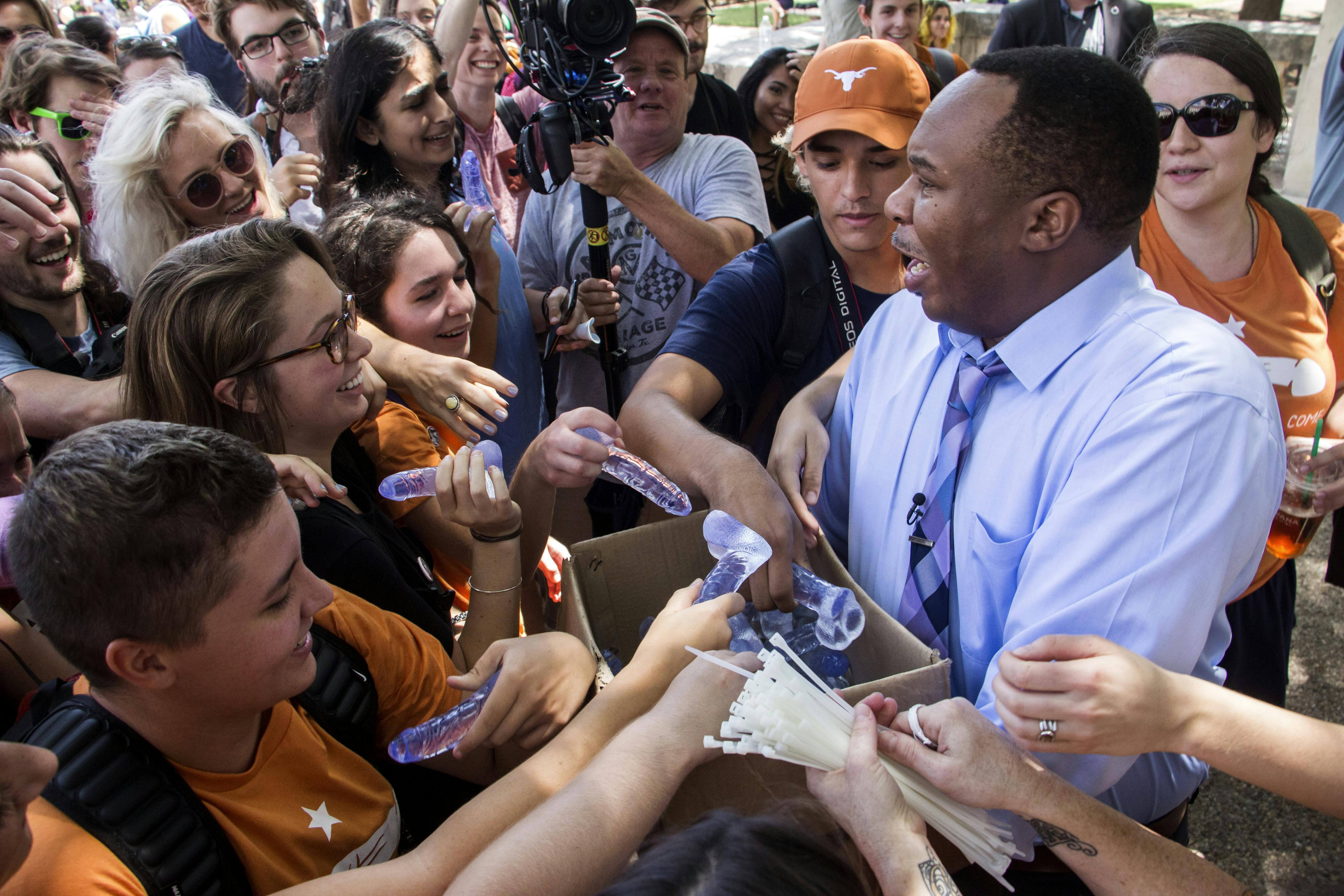 Roy Wood Jr. passes out dildos to University of Texas students.